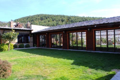 une maison avec une cour d'herbe devant elle dans l'établissement Leshtenski Perli, à Leshten