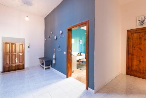 a hallway with a blue wall and a mirror at Your home in Trequanda in Trequanda