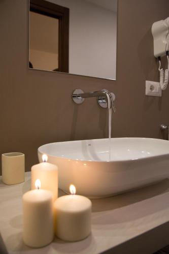 a bathroom with a tub with two candles on a counter at Borgo Medievale in Castelmola
