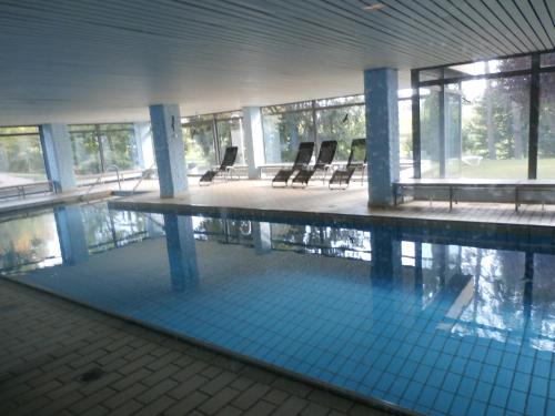 a swimming pool with chairs in a building at Bergsee in Schluchsee