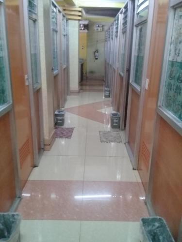 an empty hallway in a building with doors and windows at ASHBURN'S TRANSIENT BAGUIO - 3rd to 5th floor BASIC SLEEP and GO Accommodation, WITH PARKING, NO ELEVATOR in Baguio