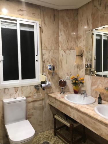 a bathroom with two sinks and a toilet and a mirror at Peso de la Harina - piso completo in Jaén