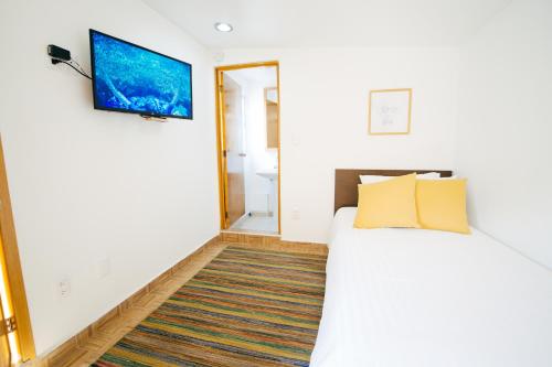 a bedroom with a bed and a tv on the wall at The Gallery in Mexico City