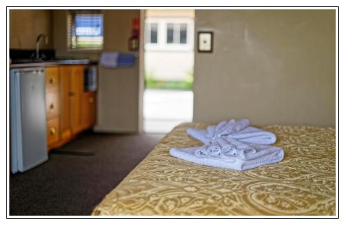 a pair of towels sitting on a bed in a kitchen at Lantern Court Motel in Reefton