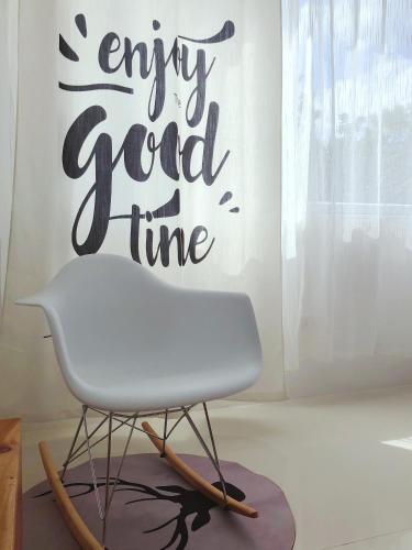 a white chair in a room with a sign that reads enjoy good time at 1949 Dreamy Home in Panglao