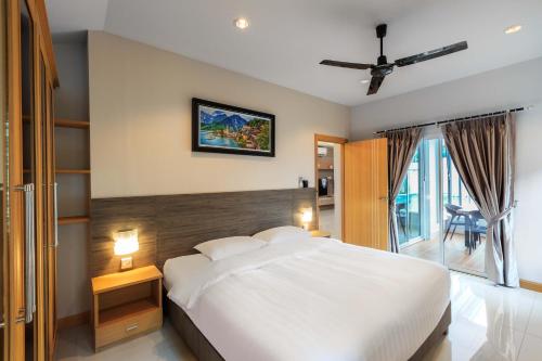 Un dormitorio con una gran cama blanca y una ventana en Gala Villa Pattaya en Pattaya South