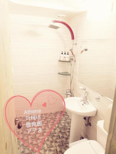 a bathroom with a heart sign on the wall at Athene Motel in Gwangju