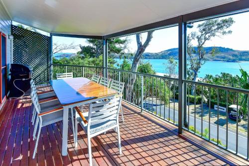 a table and chairs on a balcony with a view of the water at Hamilton Island Holiday Homes in Hamilton Island