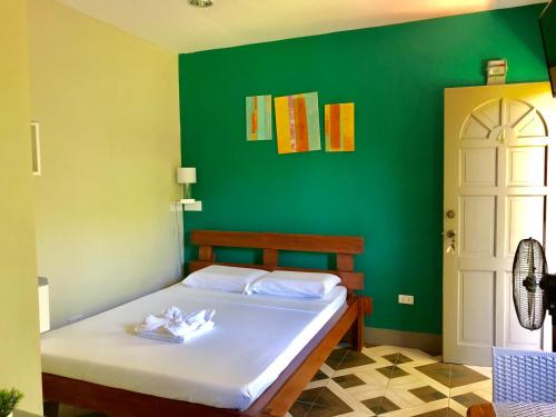 um quarto com uma cama com uma parede verde em Chaniva-Joy Island View Appartments em Malapascua