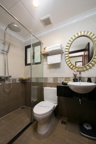 a bathroom with a toilet and a sink and a mirror at Royal Holiday Hanoi Hotel in Hanoi