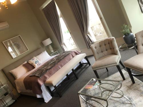 a bedroom with a bed and two windows at Bull and Mouth Hotel in Maryborough
