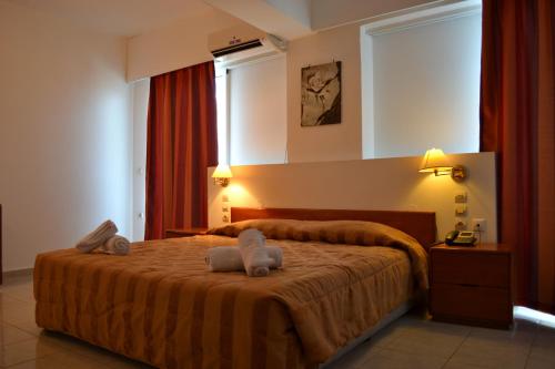 een slaapkamer met een bed met twee handdoeken erop bij Panorama Hotel Apartments in Rhodos-stad