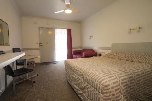 Habitación de hotel con cama, escritorio y mesa. en Centretown Motel en Nagambie