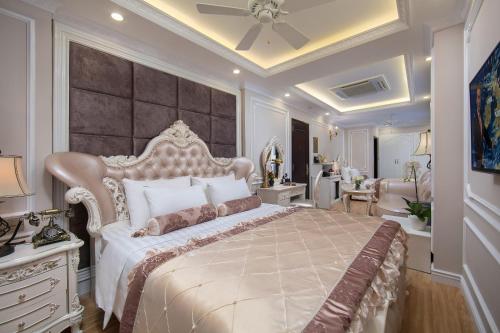 a bedroom with a large bed with a large headboard at Royal Holiday Hanoi Hotel in Hanoi