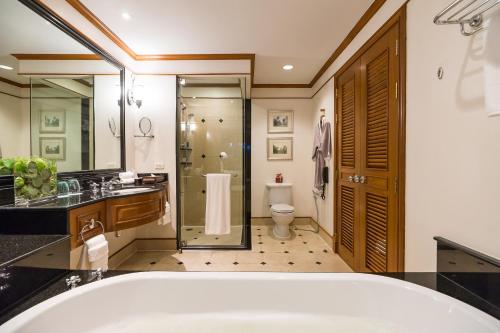 a bathroom with a tub and a shower and a toilet at JW Marriott Phuket Resort and Spa in Mai Khao Beach