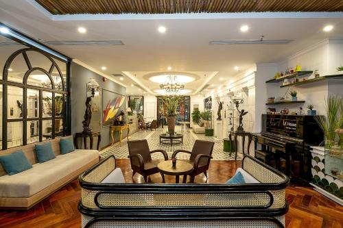 a living room with a couch and a table and chairs at Le House Boutique Hotel - 100m to the beach in Da Nang