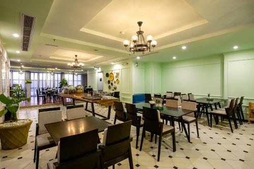a restaurant with tables and chairs in a room at Le House Boutique Hotel - 100m to the beach in Da Nang