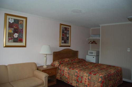 um quarto de hotel com uma cama e uma cadeira em Sea Breeze Ocean City em Ocean City