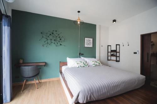 a bedroom with a bed and a green wall at Chernchan Hostel in Chanthaburi