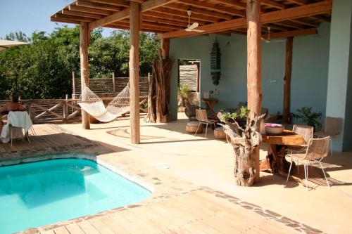 a patio with a hammock and a pool at Hotel Sal de Mar in San Agustinillo
