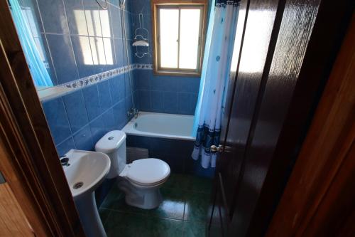Baño azul con aseo y lavamanos en Cabaña Vintage, en Algarrobo