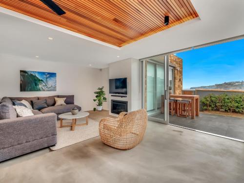 a living room with a couch and a table at Tamarama Apartments in Sydney