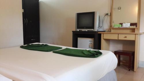 a bedroom with a white bed with a tv on a desk at Phi Phi View Point Resort in Phi Phi Don