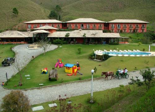 un bâtiment avec une aire de jeux pour les personnes et un cheval et une calèche dans l'établissement Hotel Fazenda Jecava, à Teresópolis