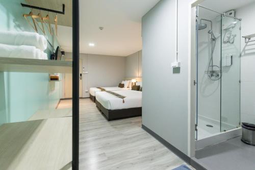 a hotel room with a bed and a glass shower at Siam Stadium Hostel in Bangkok