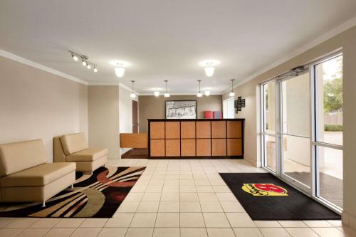 a living room with a waiting area with a couch and chair at Super 8 by Wyndham Lake Charles Northeast in Lake Charles