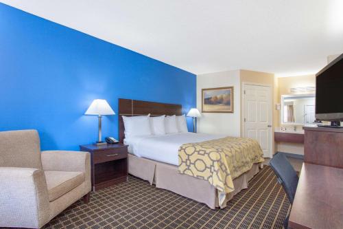 a hotel room with a bed and a couch at Baymont by Wyndham Greenwood in Greenwood