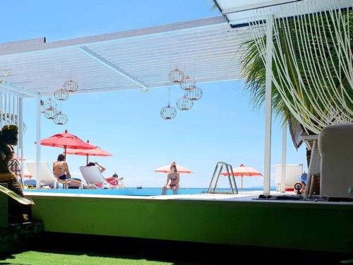 Phangan Cove Beach Resort في سورات ثاني: مجموعة من الناس واقفين حول مسبح