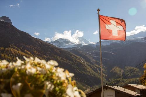 a red flag with a white arrow on a mountain at Boutique Lodge Spycher in Saas-Fee