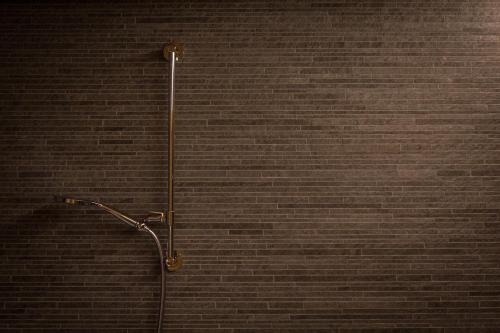 a shower in a bathroom with a brick wall at Boutique Lodge Spycher in Saas-Fee