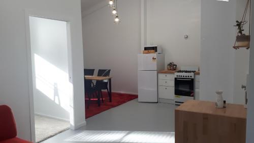a white kitchen with a table and a refrigerator at Stay @ The Cube in Montville