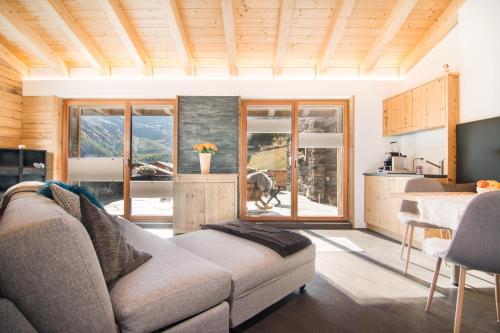 a living room with a couch and a kitchen at Boutique Lodge Spycher in Saas-Fee