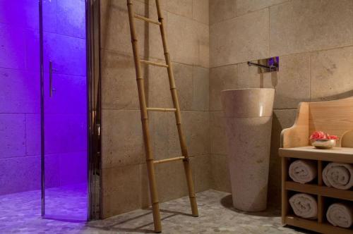 a wooden ladder in a bathroom with purple lights at Le Cottage - Hotel & Spa in Argelès-sur-Mer
