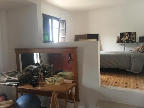 グラナダにあるCasa en el Albaicinのベッド、デスク、テーブルが備わる客室です。