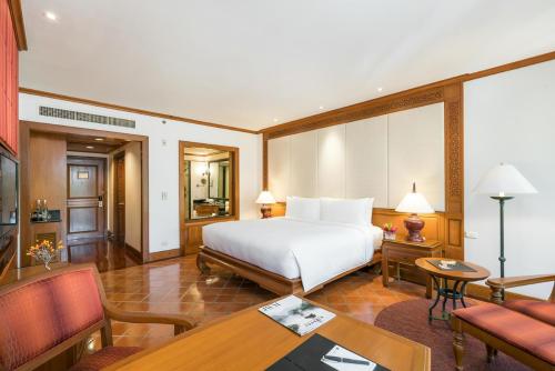 a hotel room with a bed and a dining room at JW Marriott Phuket Resort and Spa in Mai Khao Beach