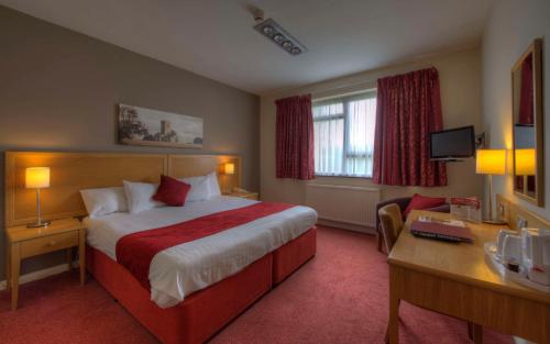 Habitación de hotel con cama grande y escritorio. en Kingstown Hotel by Greene King Inns, en Hull