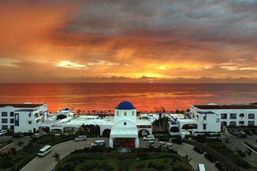 a view of a building with a sunset in the background at Thunderbird Resorts - Poro Point in San Fernando
