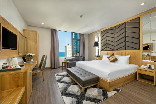 a bedroom with a bed and a desk and a television at Grand Sunrise Boutique Hotel in Da Nang