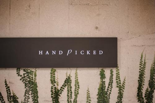 a sign that reads hand picked next to a group of cactus at Handpicked Hotel & Collections in Seoul