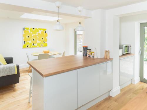 a kitchen with white walls and a wooden counter top at Teviot Cottage in Corbridge