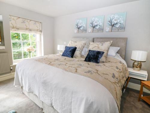 a bedroom with a large white bed with blue pillows at Castle Hill in Bakewell