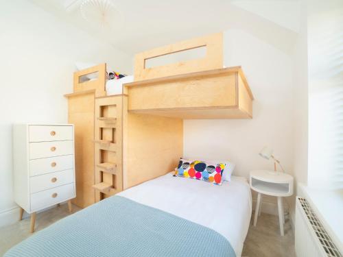 a small bedroom with a bunk bed and a desk at Teviot Cottage in Corbridge