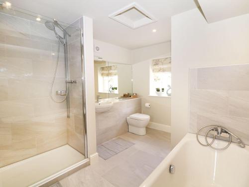 uma casa de banho com um chuveiro, um WC e um lavatório. em Castle Hill em Bakewell