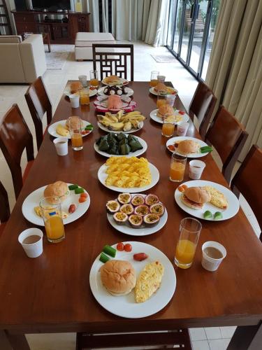 岘港Emblem Sea 4 Bedroom Villas的一张木桌,上面放着食物和饮料