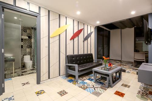 a living room with a black chair and a table at Le House Boutique Hotel in Danang