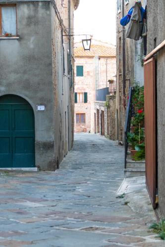 an alley with a green door in a building at Your home in Trequanda in Trequanda